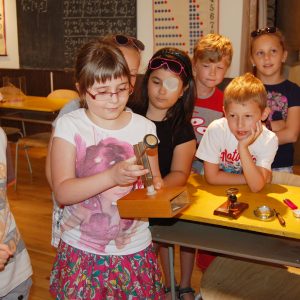 Žiaci s historickými učebnými pomôckami.