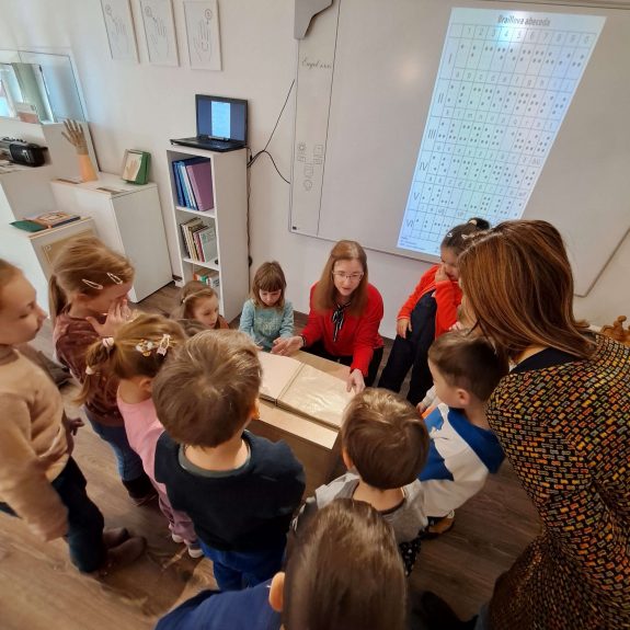 Návštevníci v múzeu Detskí návštevníci prezerajúci si knihu pre nevidiacich v priestoroch Múzea špeciálneho školstva v Levoči.