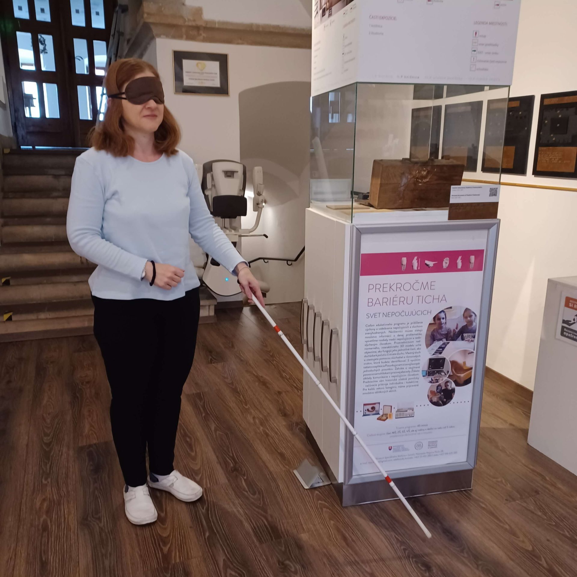 Lektorka Lucia predvádza chôdzu s bielou slepeckou palicou.