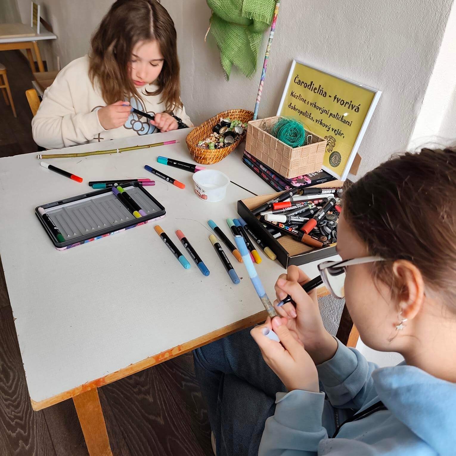 Návštevníci kreatívne tvoriaci na workshopoch.