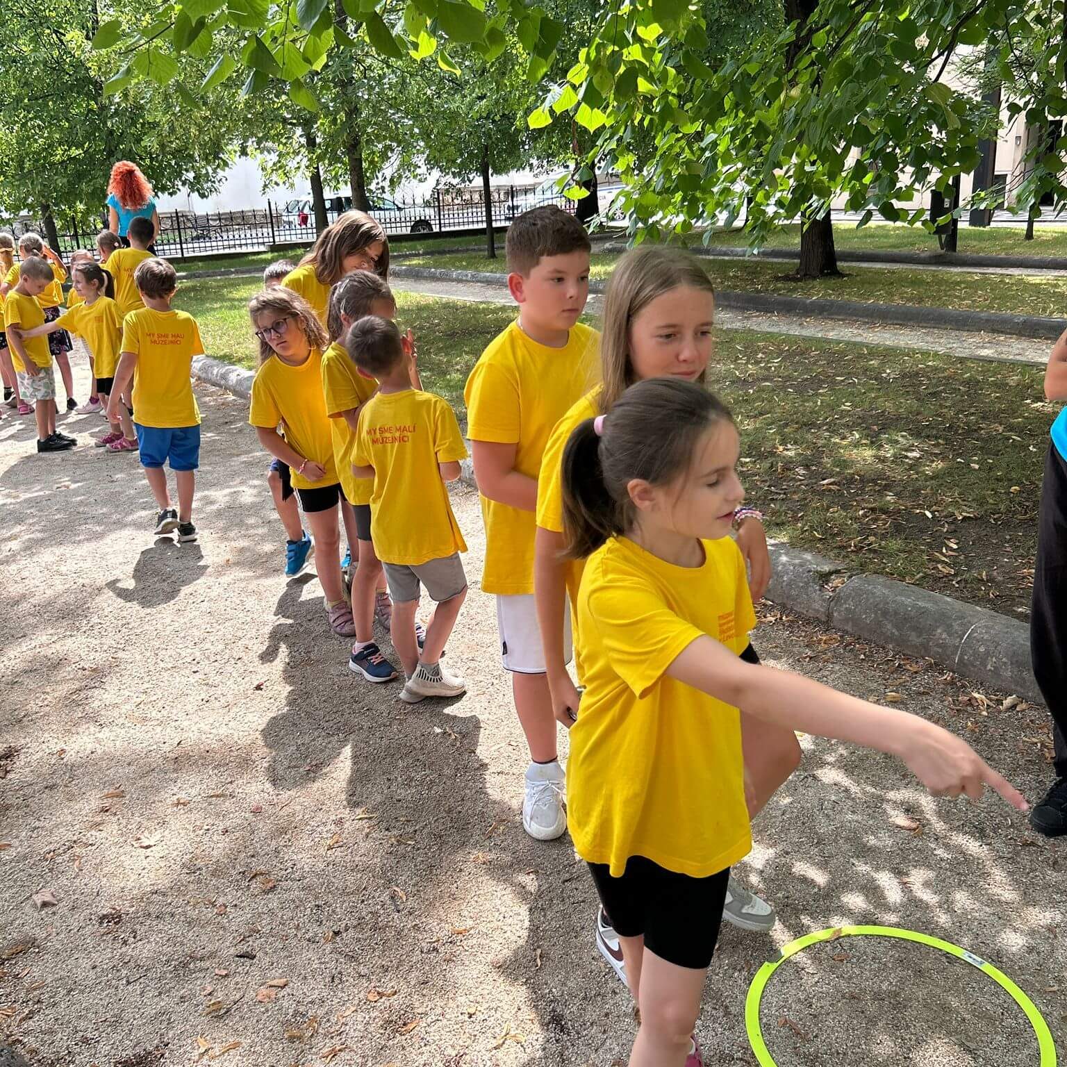 Malí múzejníci v mestskom parku pri aktivitách.
