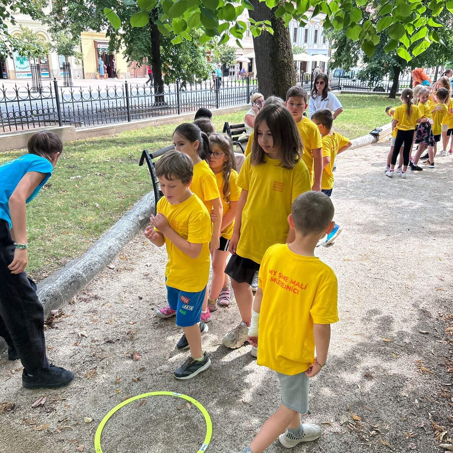 Malí múzejníci v mestskom parku pri aktivitách.