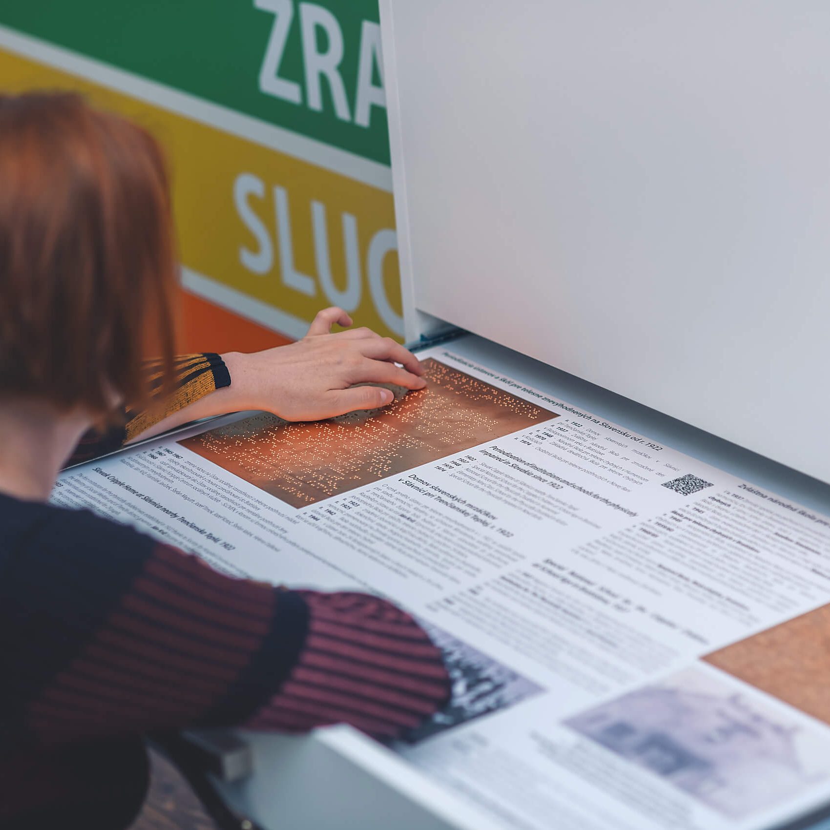 Nevidiaca návštevníčka si číta o špeciálnych školách.