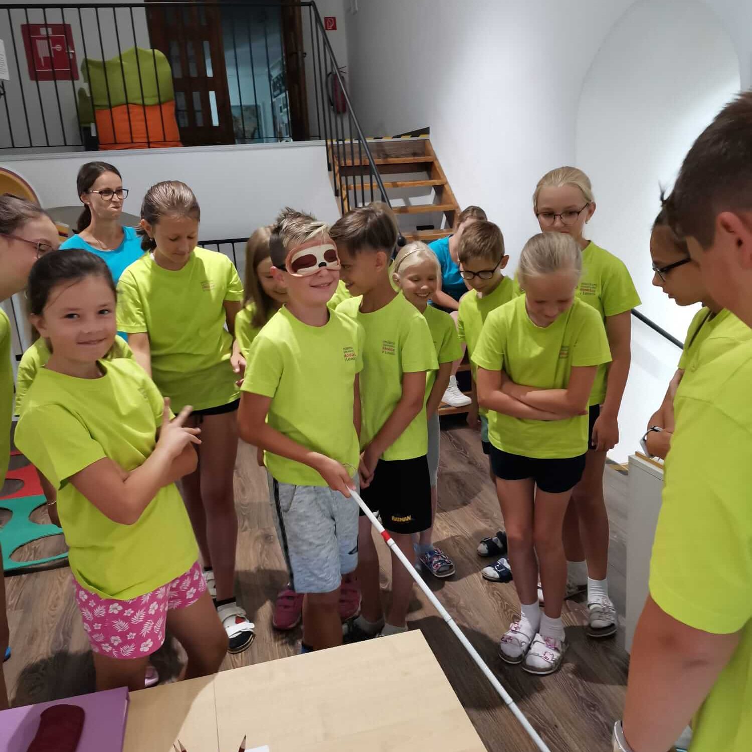 Návštevníci skúšajúci chôdzu s bielou palicou.