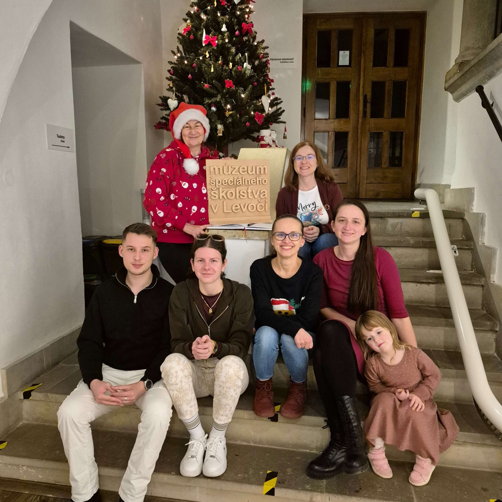 Pracovníci múzea počas vianočného obdobia pri vianočnom stromčeku.